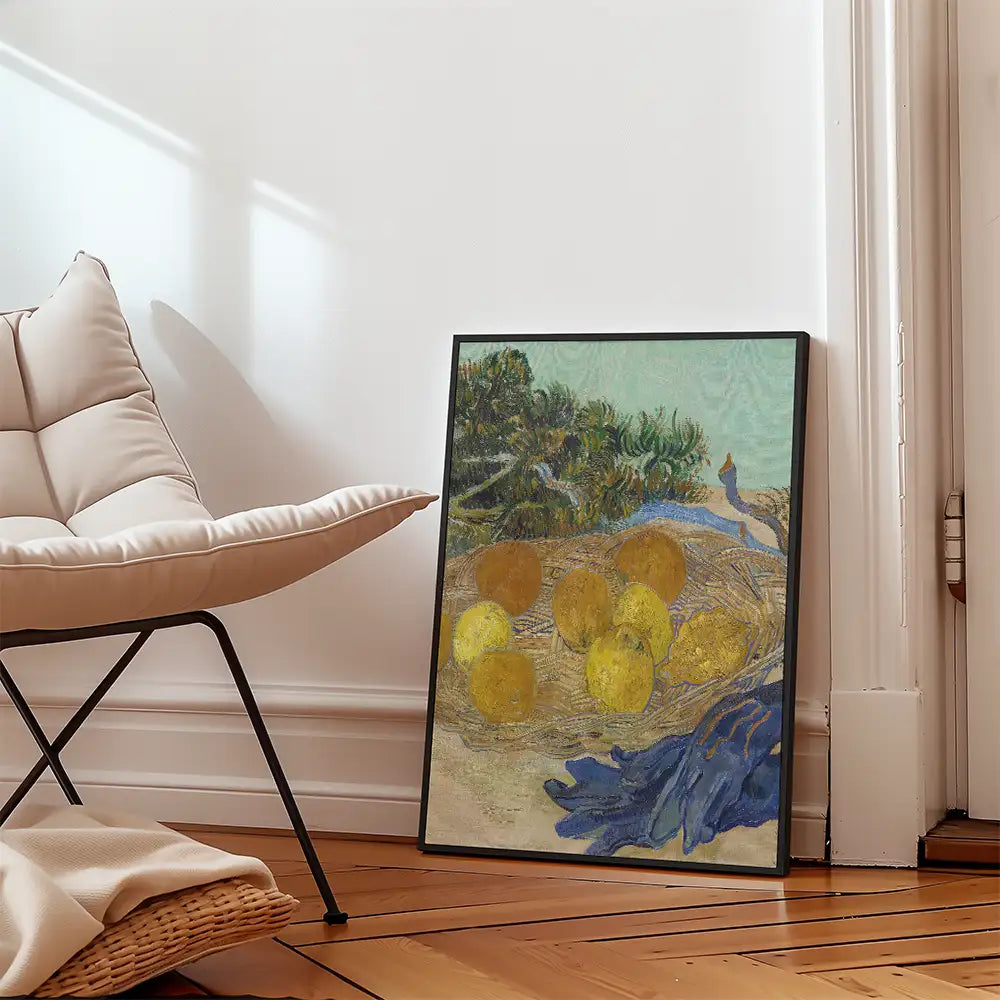 Framed painting of a nest with yellow eggs and a blue background leaning against a wall next to a modern chair.