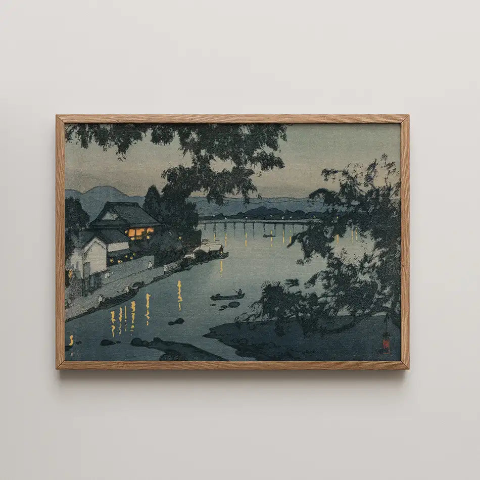 Framed painting of a serene riverside scene at dusk, featuring reflections of lights on the water and outlined silhouettes of trees and mountains.