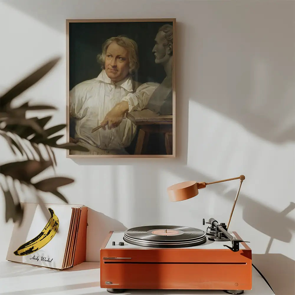 Painting of a man thinking, framed on a wall above a vintage turntable and record collection.