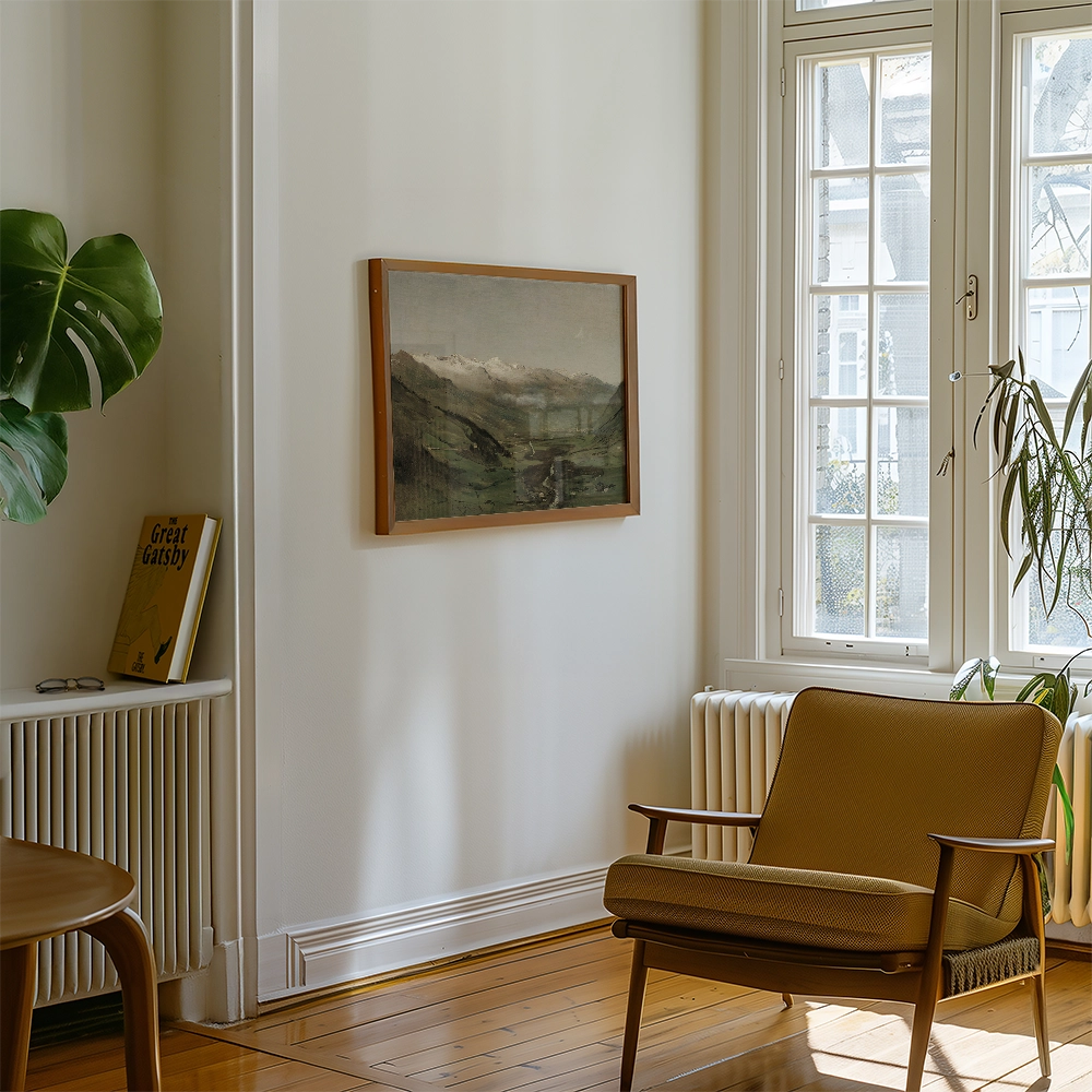 Framed painting of a mountainous landscape hanging on a white wall in a modern living room with a chair, plant, and book.