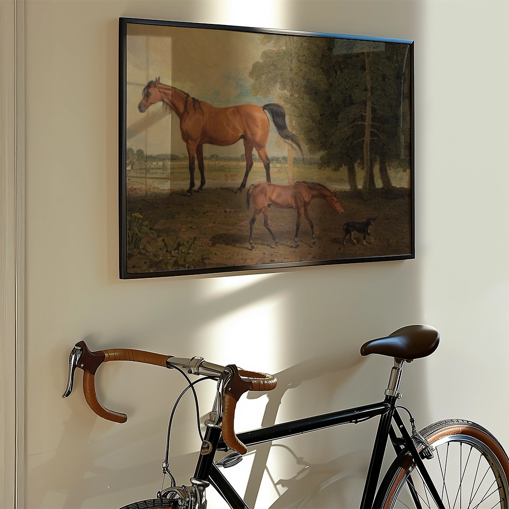 Painting of two horses and a dog in a natural landscape, displayed on a wall above a vintage bicycle.