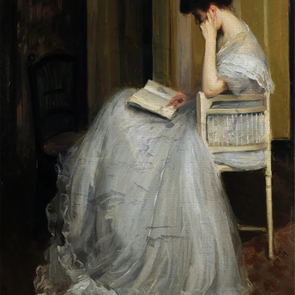 Young woman in a white gown sitting on a chair, reading a book with a contemplative expression, in a softly lit interior.
