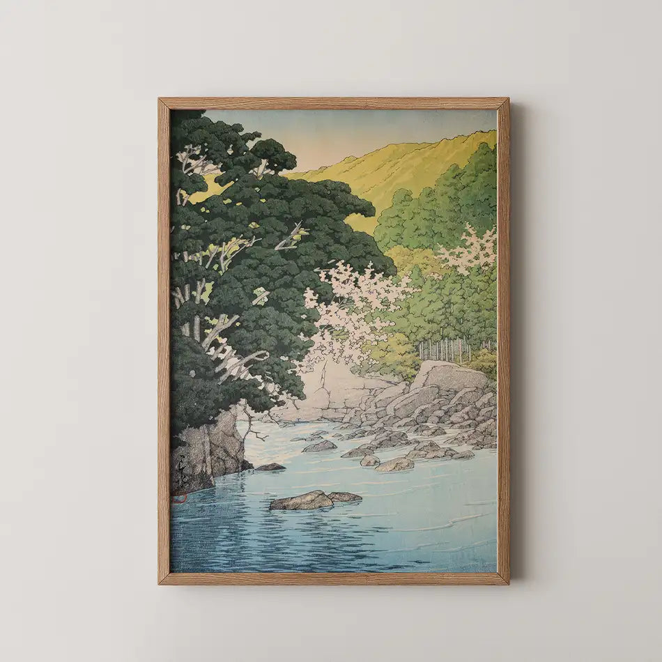 Framed painting of a serene landscape featuring a river, lush trees, and cherry blossoms with soft colors and intricate details.