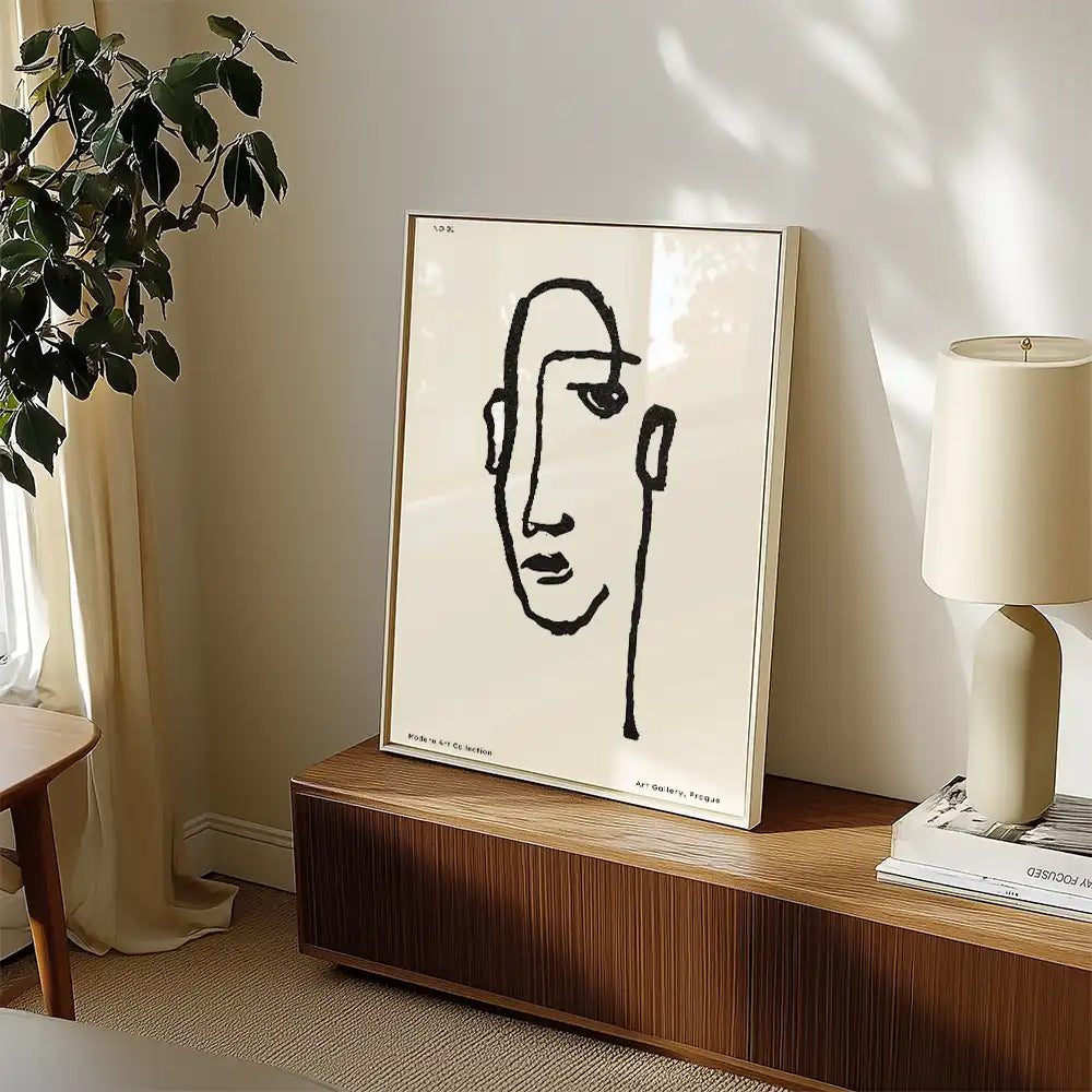 Modern minimalist poster of a famous painting featuring a linear abstract face design, displayed in a stylish living room setting with natural light and decorative elements.