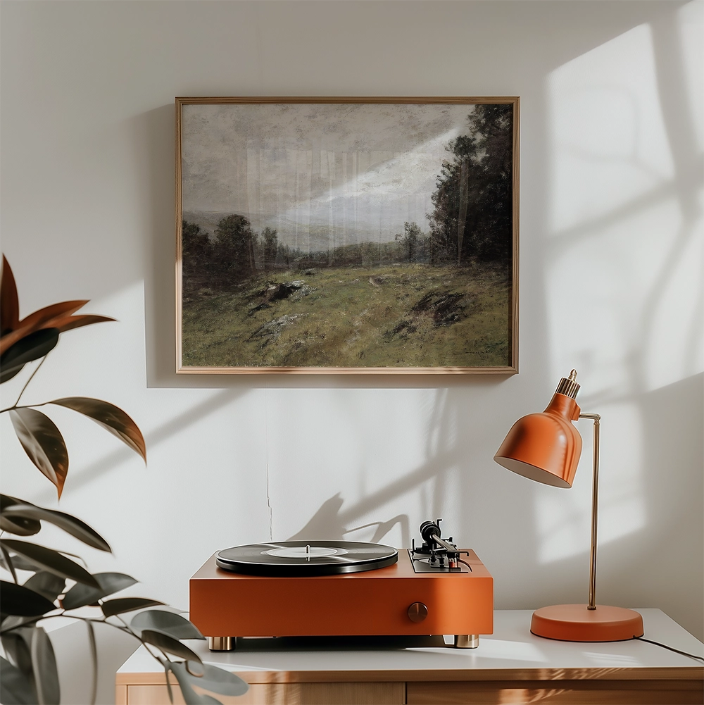 A serene landscape painting framed in gold, displayed on a wall above an orange record player and lamp, with natural light filtering into the room.
