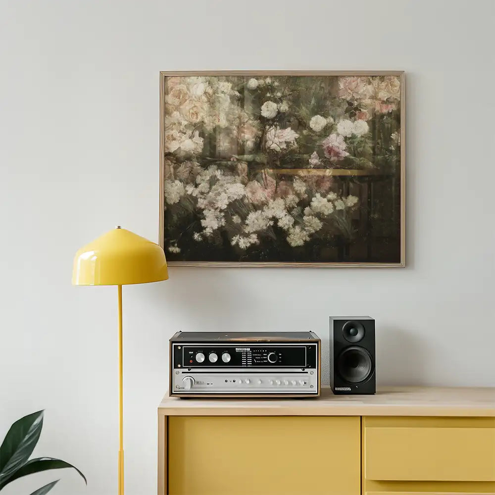 Painting of soft, pastel flowers in a wooden frame, displayed above a vintage record player and a yellow lamp in a modern interior setting.