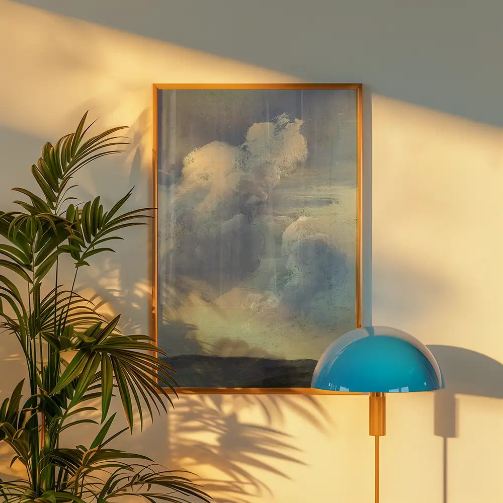 Abstract painting of clouds in a wooden frame, illuminated by soft light, accompanied by a modern blue lamp and green plant.