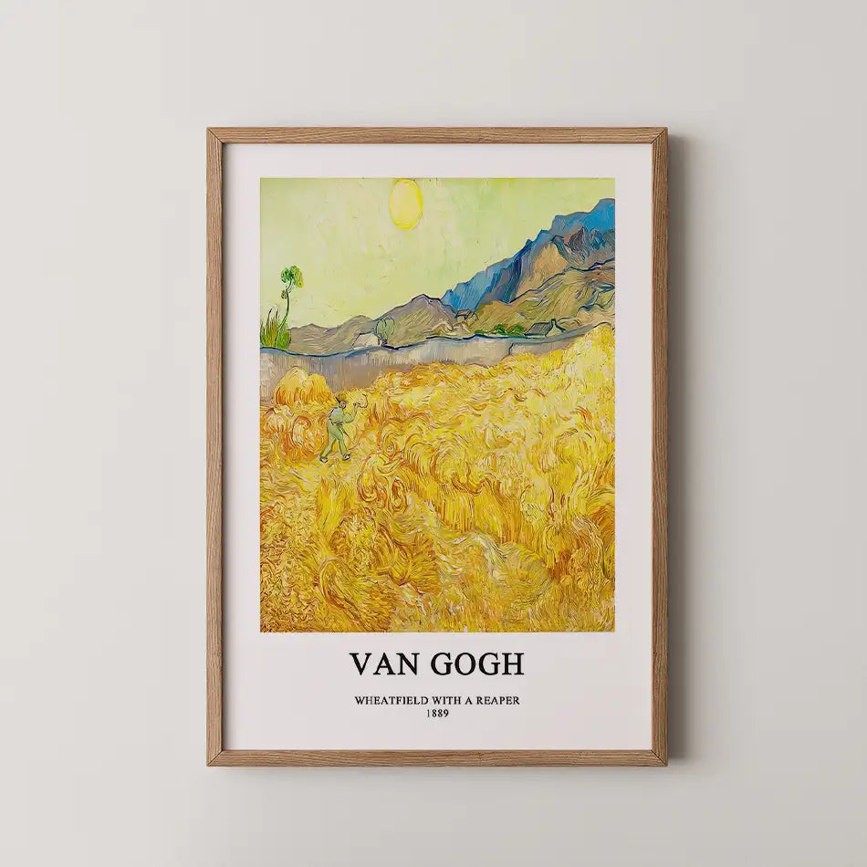 Framed poster of Van Gogh's "Wheatfield with a Reaper," featuring vibrant fields of wheat and mountains in the background, with the title and date displayed below the artwork.
