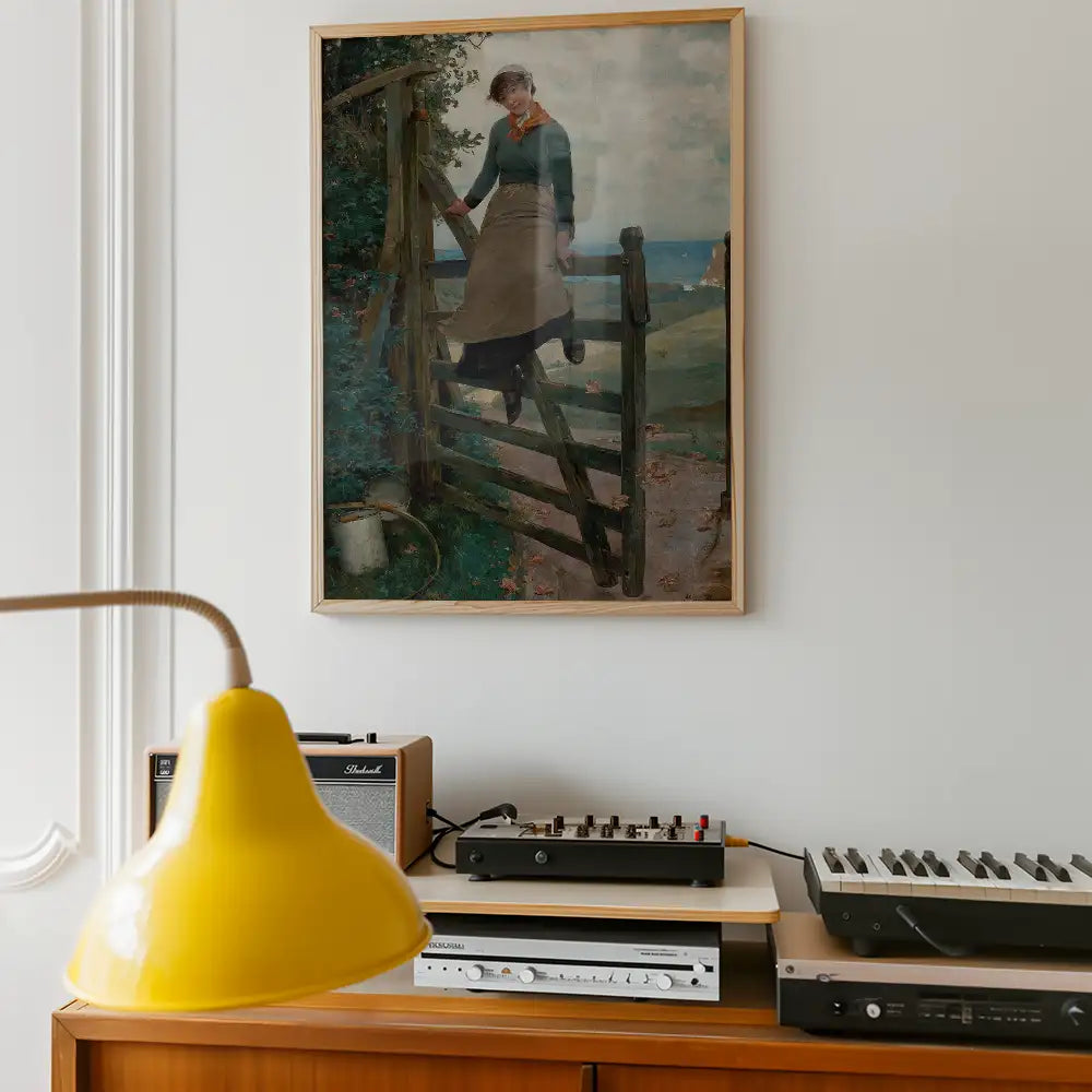 Painting of a woman stepping over a wooden gate in a countryside landscape, framed and displayed on a wall above a vintage audio setup and a yellow lamp.