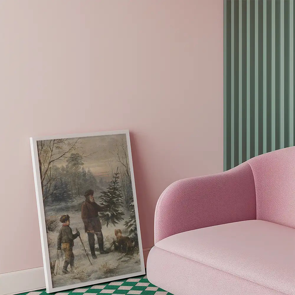Framed painting of two boys and a man interacting with a Christmas tree in a winter landscape, placed beside a pink sofa in a modern interior setting.