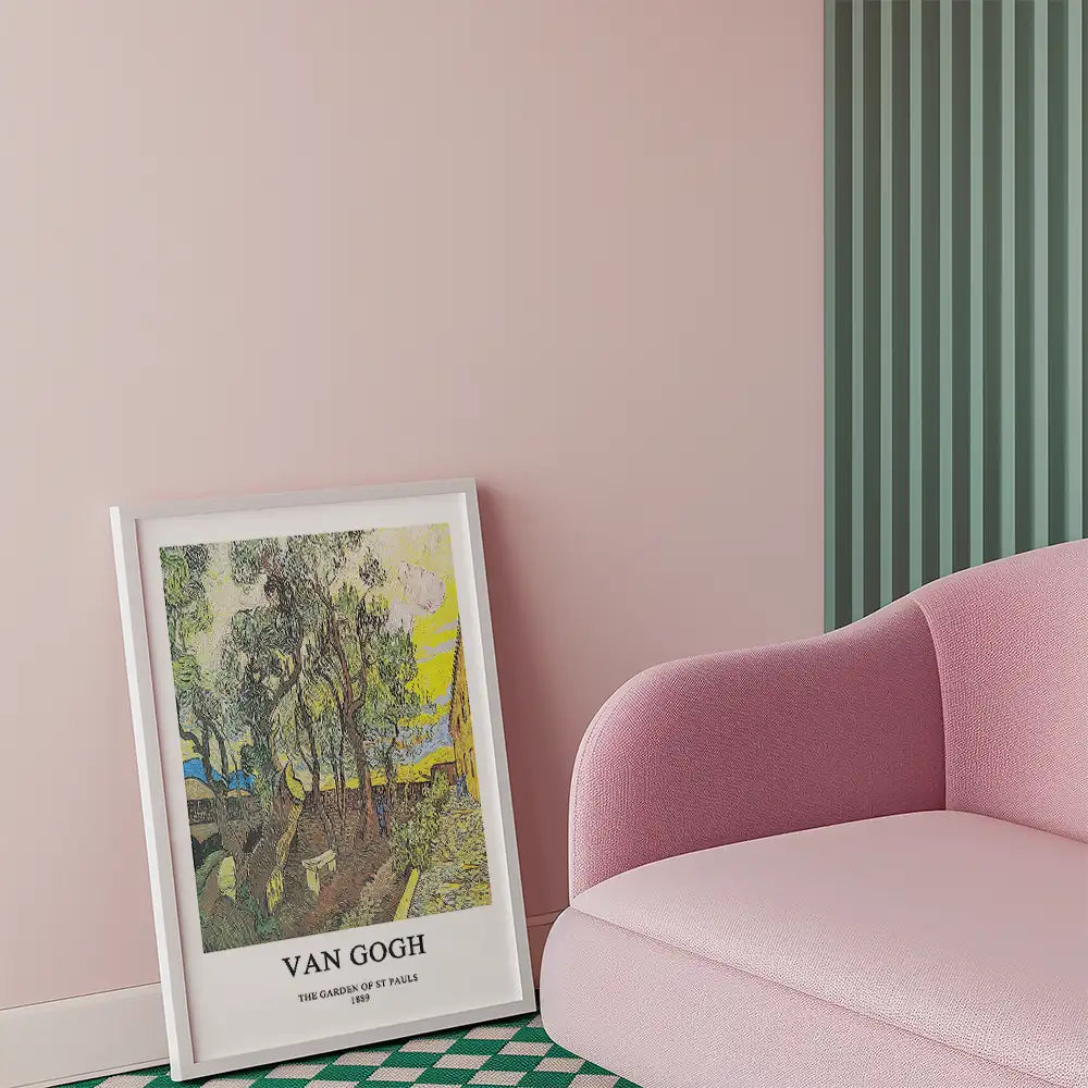 Framed poster of Van Gogh's "The Garden of St. Pauls" leaning against a wall, with a pink sofa nearby.