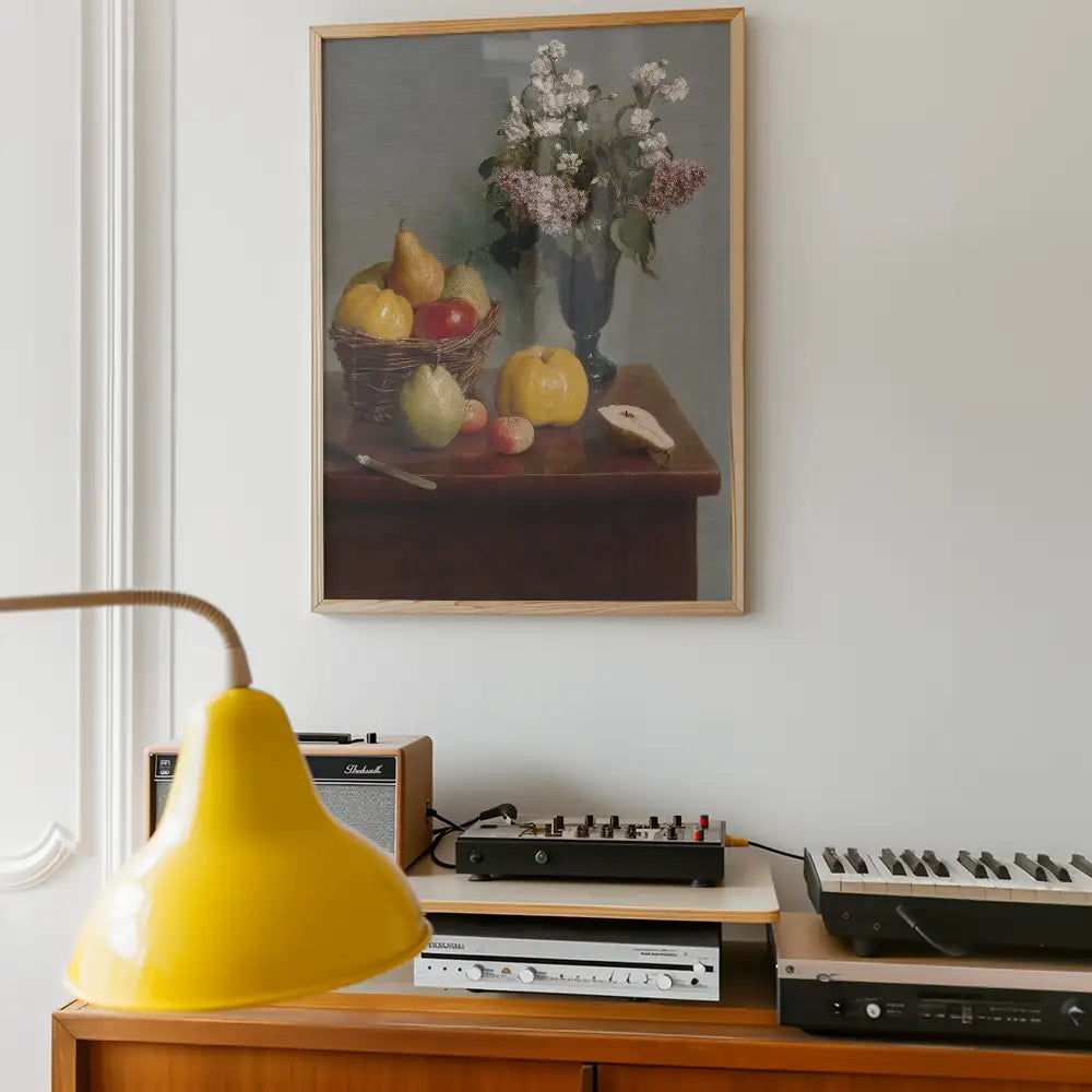 Still life painting featuring fruits and flowers in a vase, displayed on a wall above a wooden table with a yellow lamp, vintage audio equipment, and a decorative setting.