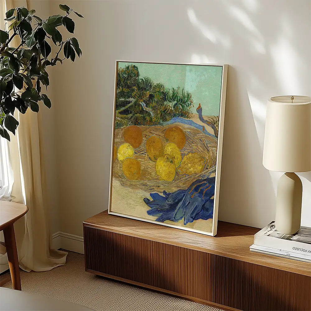 Framed painting of a nest with yellow eggs and a blue-gloved hand, displayed in a modern living room setting with a plant and lamp.