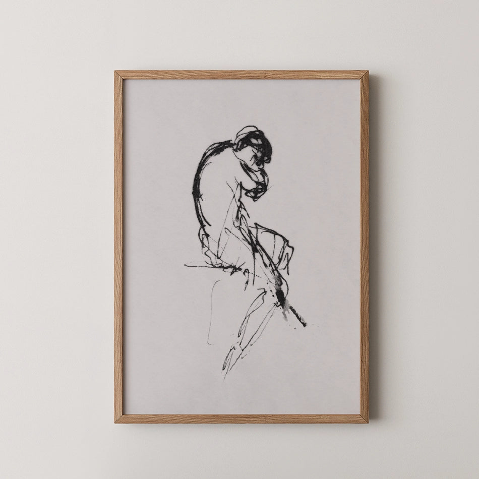 Framed black and white sketch of a seated figure, displayed against a neutral background.
