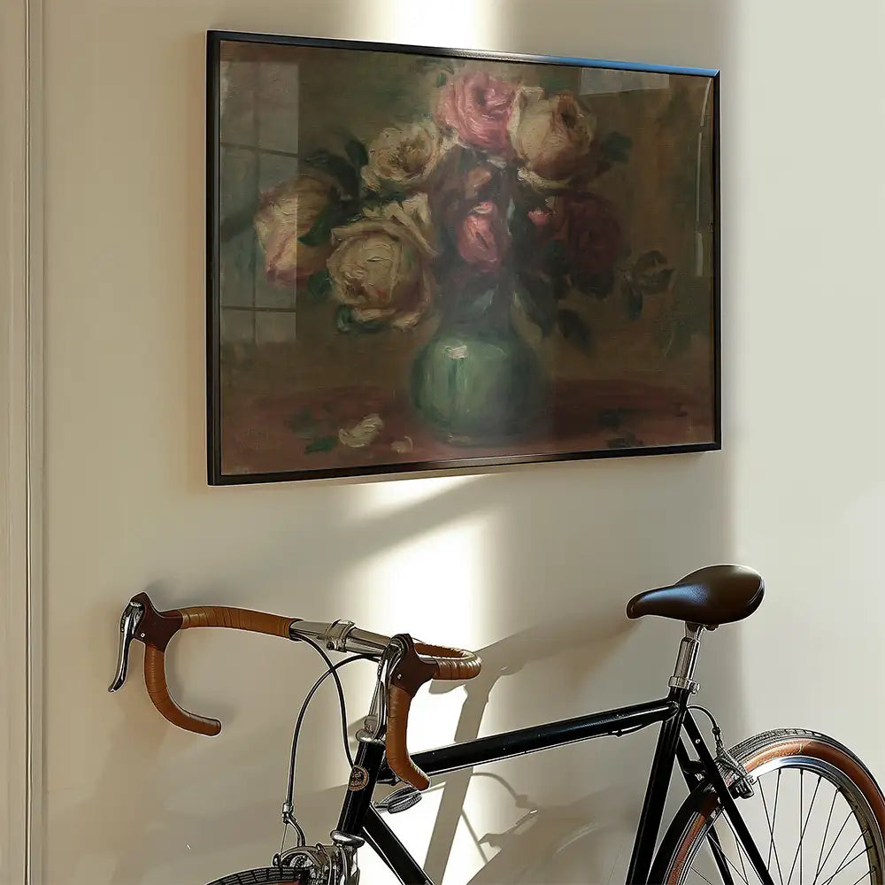 Framed painting of a bouquet of roses in a green vase hanging on a wall beside a vintage bicycle.