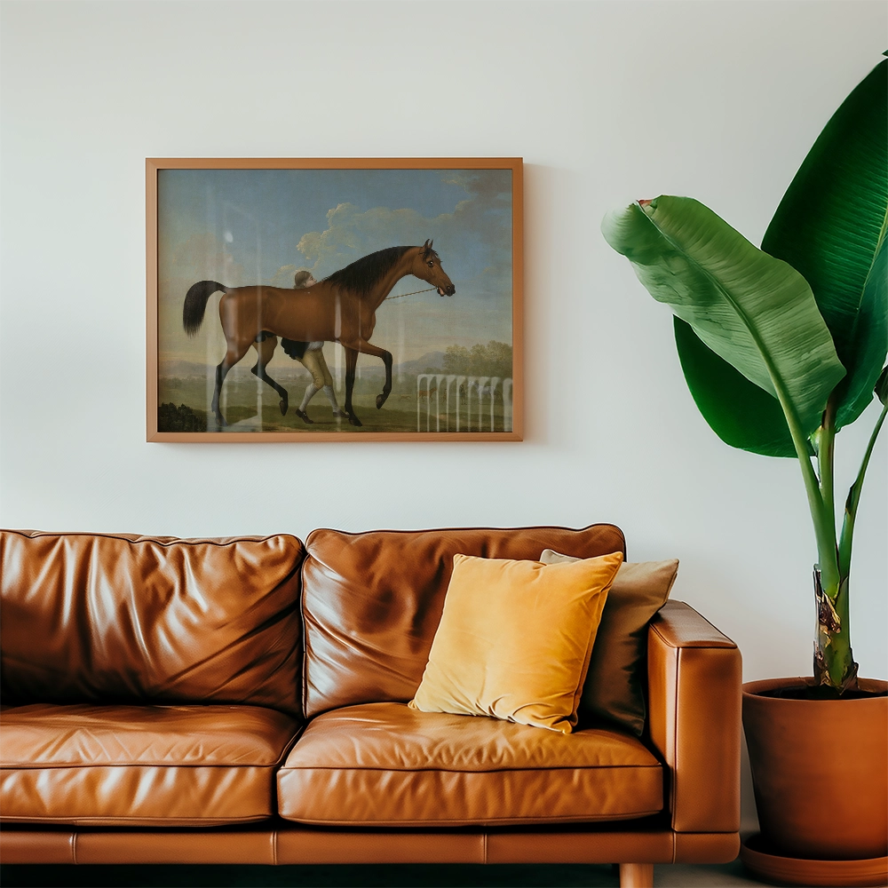 Framed painting of a horse walking, displayed above a brown leather sofa with decorative pillows, alongside a green plant.