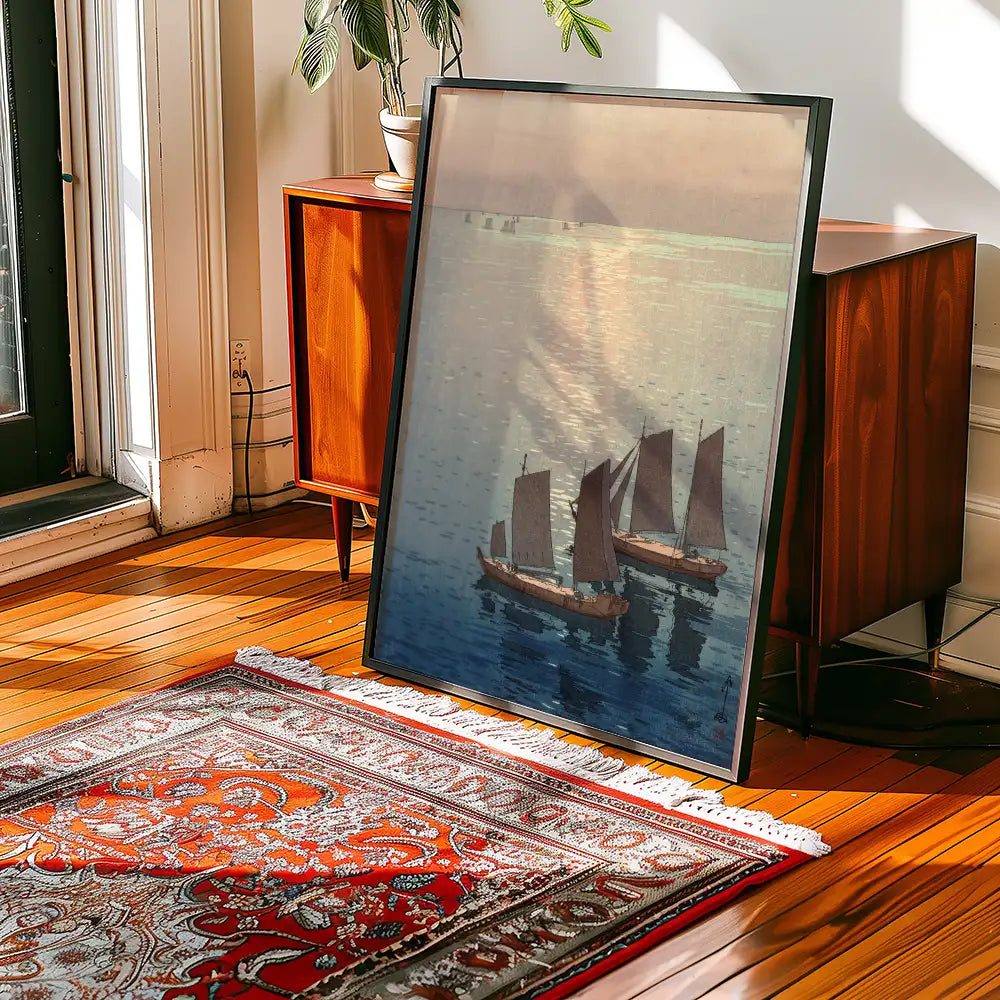 Framed painting of three boats with sails on calm water, leaning against a wooden side table in a sunlit room with a patterned rug.