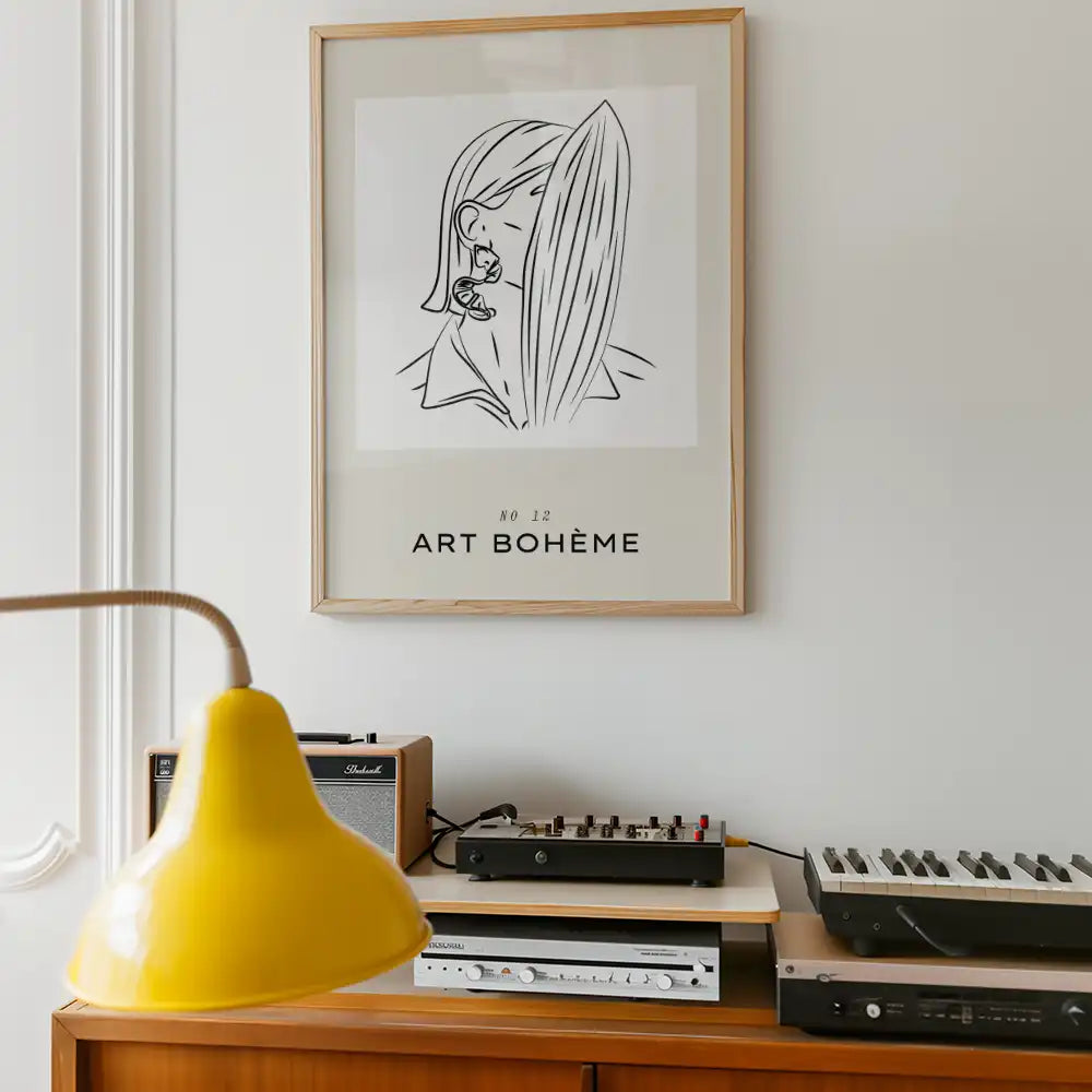 Modern minimalist poster featuring a line drawing of a woman, framed and titled "Art Bohème," displayed in a stylish interior setting alongside retro audio equipment and a yellow lamp.