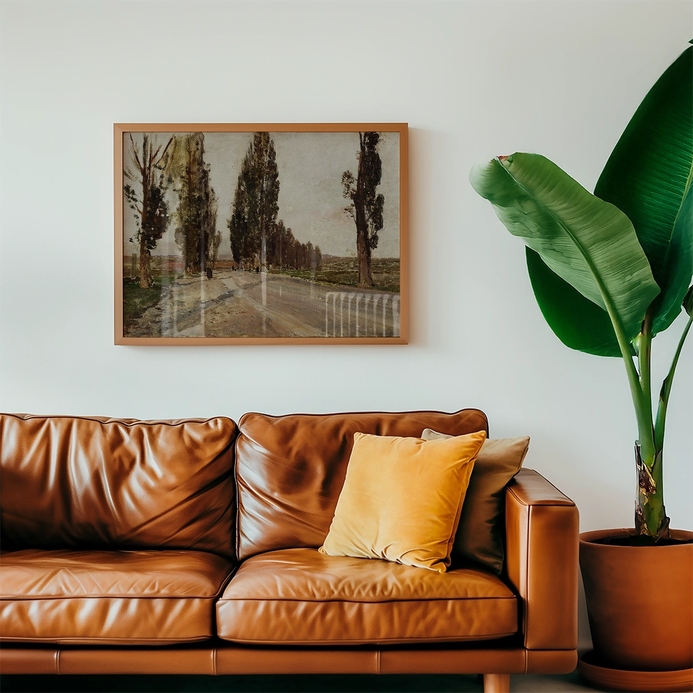 Framed painting of a tree-lined pathway hanging above a brown leather sofa with decorative pillows and a potted plant.