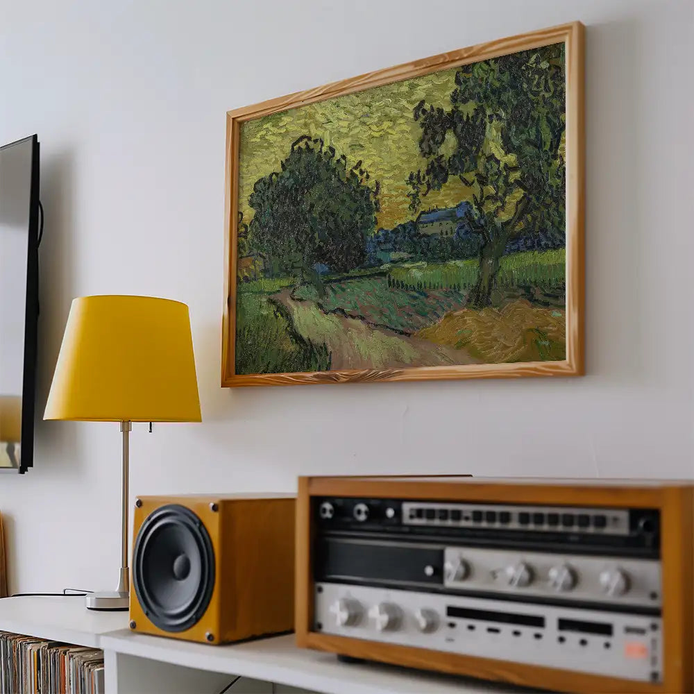 Framed landscape painting on a wall with a yellow lamp and wooden audio equipment in a modern interior setting.