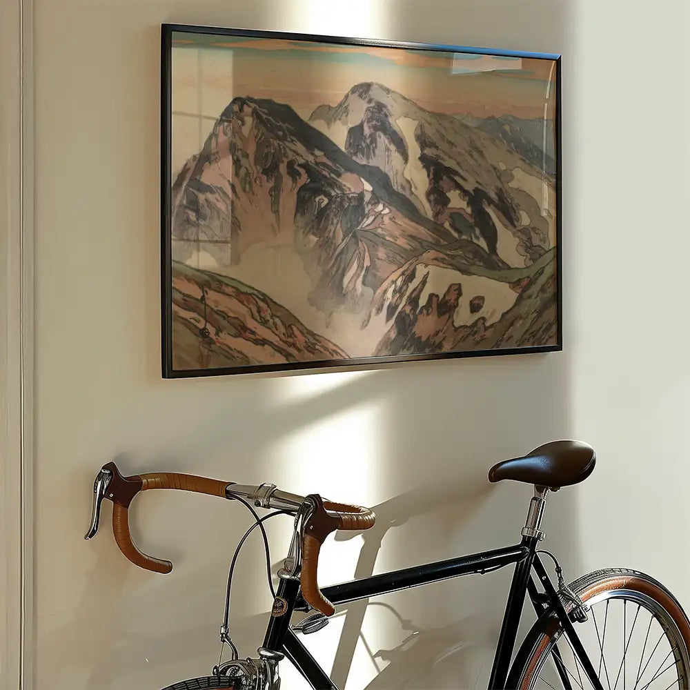 Mountain landscape painting framed and displayed on a wall next to a vintage bicycle with brown leather accents.