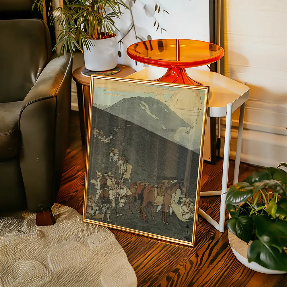 Framed painting of a historical scene with people and horses, displayed in a stylish living room setting alongside a modern side table and potted plant.