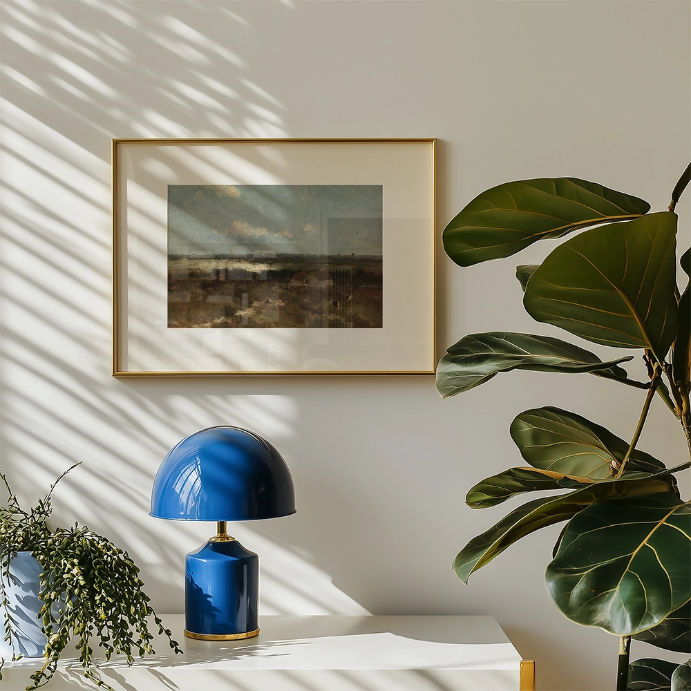 Framed landscape painting on a wall, complemented by a blue lamp and a leafy plant, with sunlight casting shadows.