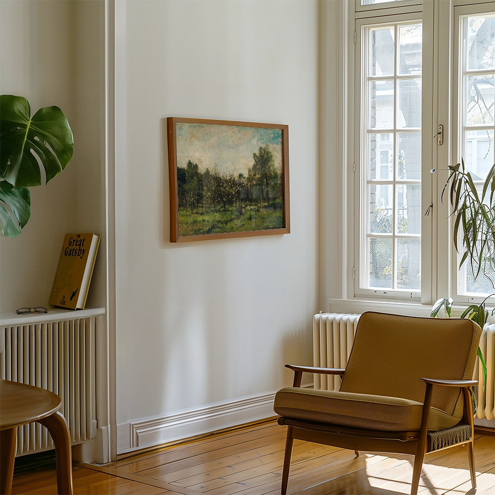 Framed landscape painting on a wall in a bright living room with a green plant and a brown armchair.