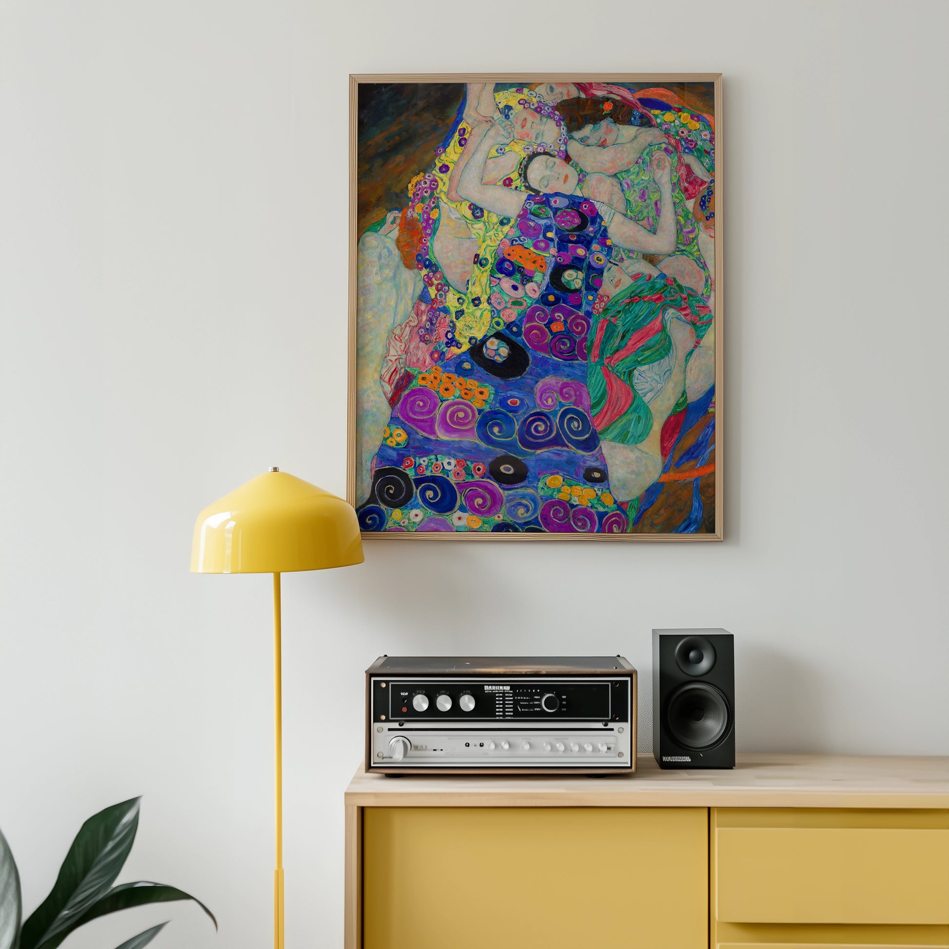 Colorful abstract painting in a wooden frame, displayed on a wall above a vintage stereo system and a yellow floor lamp in a modern interior setting.