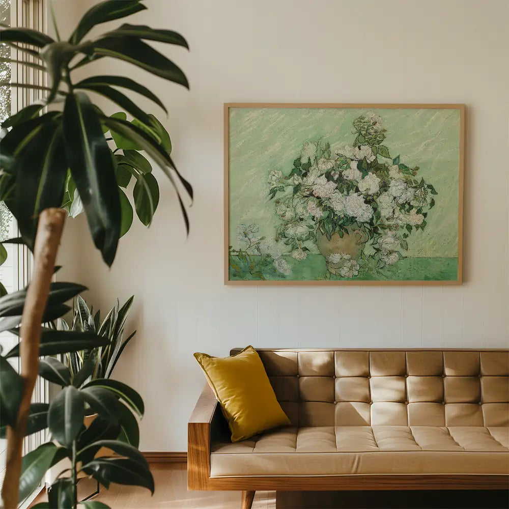 Framed painting of white flowers in a vase on a green background, displayed in a modern living room setting with a leather sofa and indoor plants.