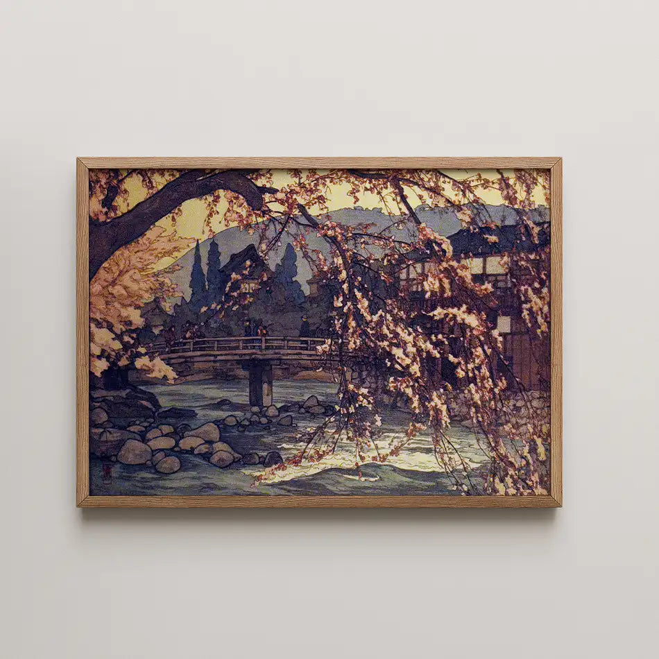 Framed painting of a serene landscape featuring a bridge over a river surrounded by cherry blossom trees and mountains in the background.