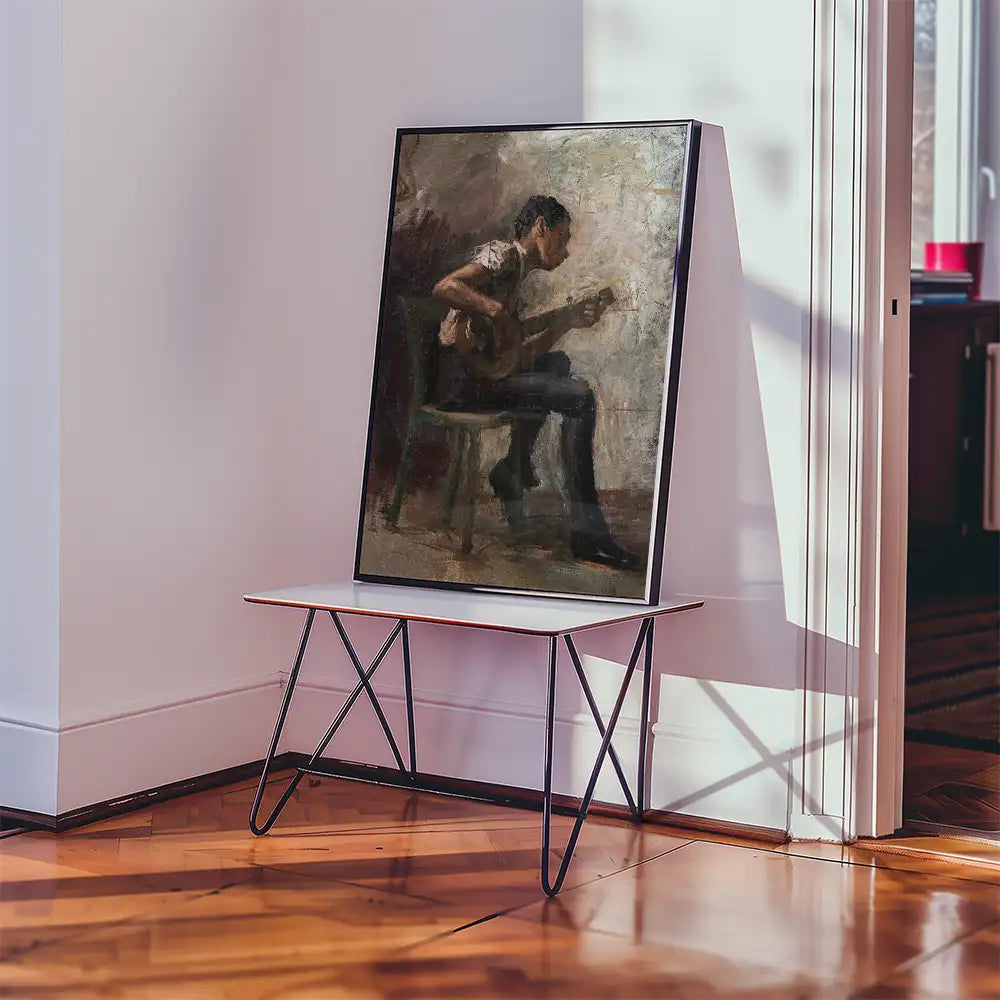 Painting of a man sitting on a chair and playing the guitar, displayed on an easel table in a well-lit interior.