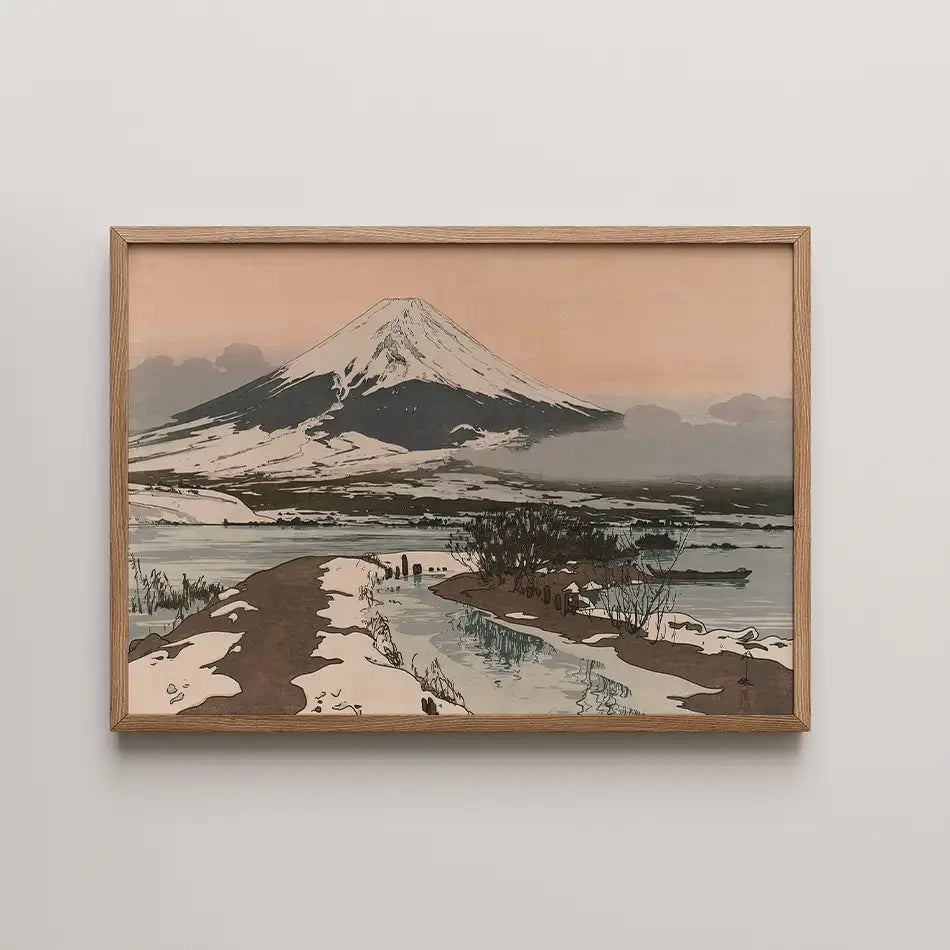 Framed painting of Mount Fuji covered in snow with a serene roadway and waterway in the foreground, set against a soft peach sky.