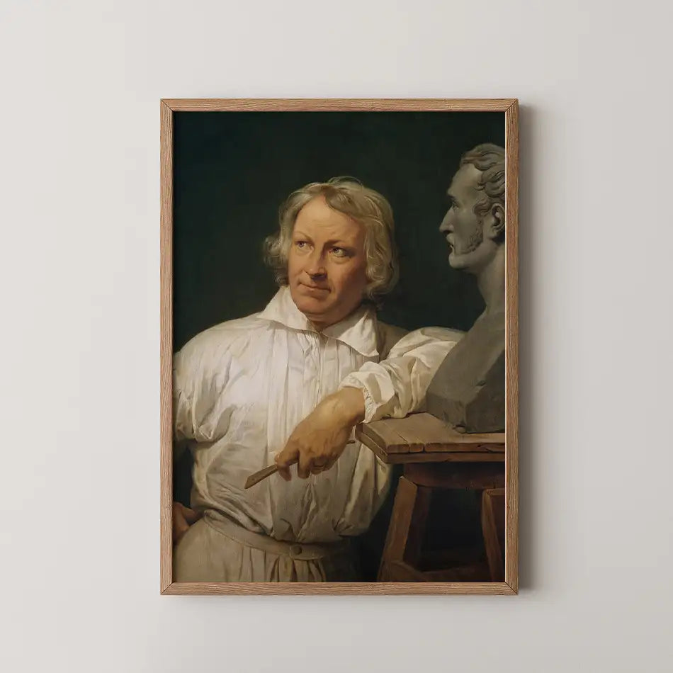 Portrait of a man with a thoughtful expression, dressed in a white shirt, standing beside a bust sculpture, framed in wood.