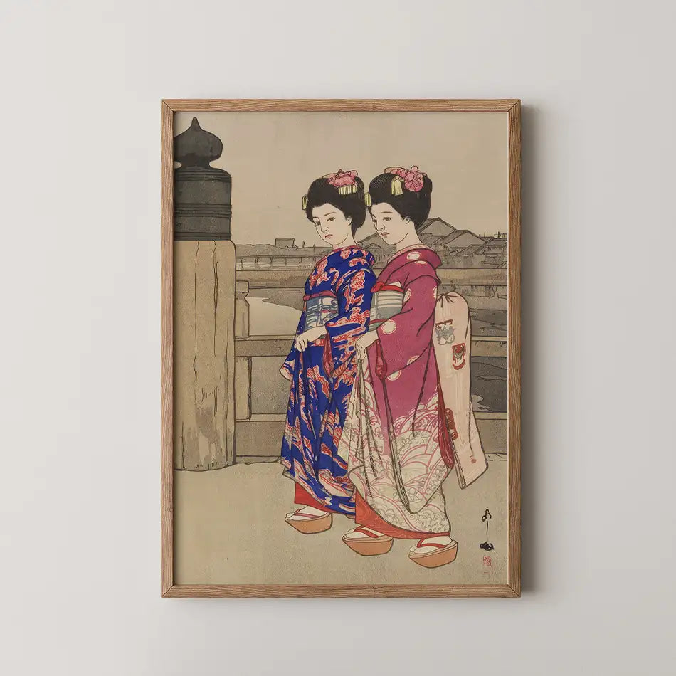 Traditional Japanese artwork featuring two women in colorful kimonos, framed and displayed on a white wall.