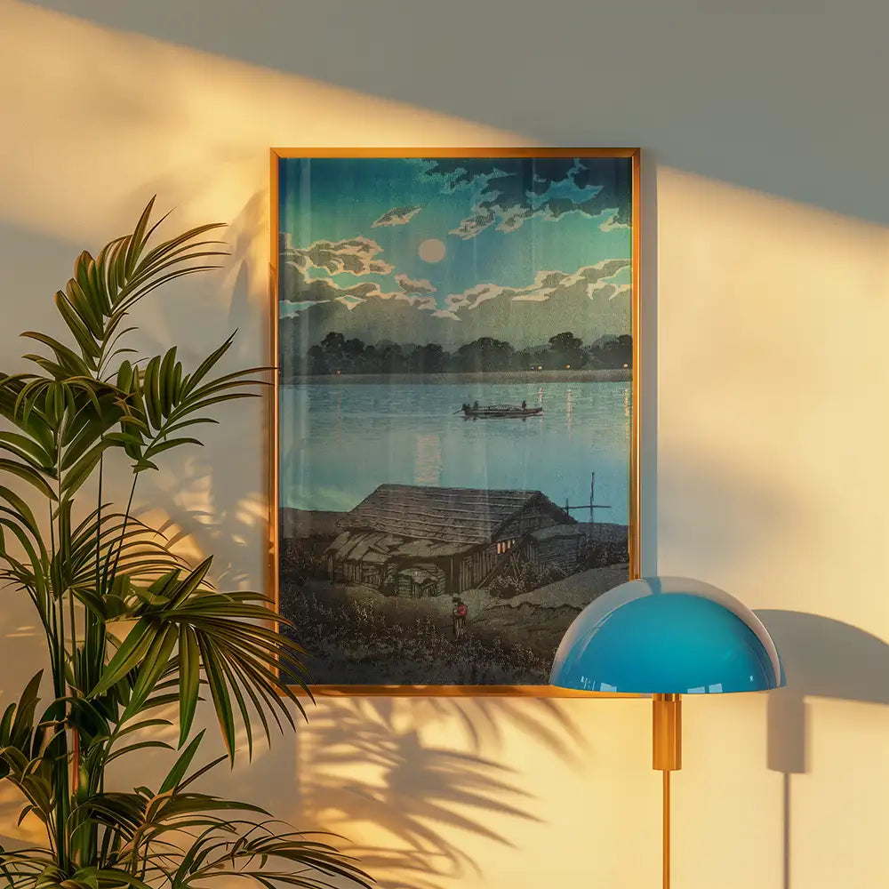 Framed painting of a serene lakeside scene with a boat and clouds reflecting the moonlight, displayed on a wall next to a potted plant and a modern lamp.