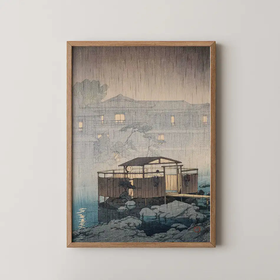 Framed painting of a wooden structure on a rocky shore with rain falling and soft lighting in the background.