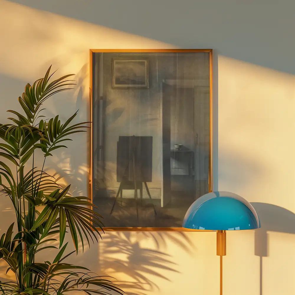 Framed painting on a wall with warm light, accompanied by a potted plant and a modern lamp.