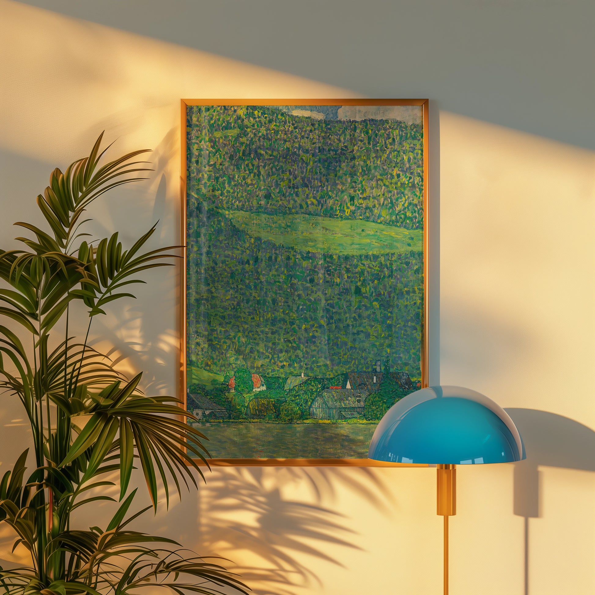 Framed painting of a lush green landscape with a hint of buildings, displayed on a wall beside a modern lamp and a potted plant.