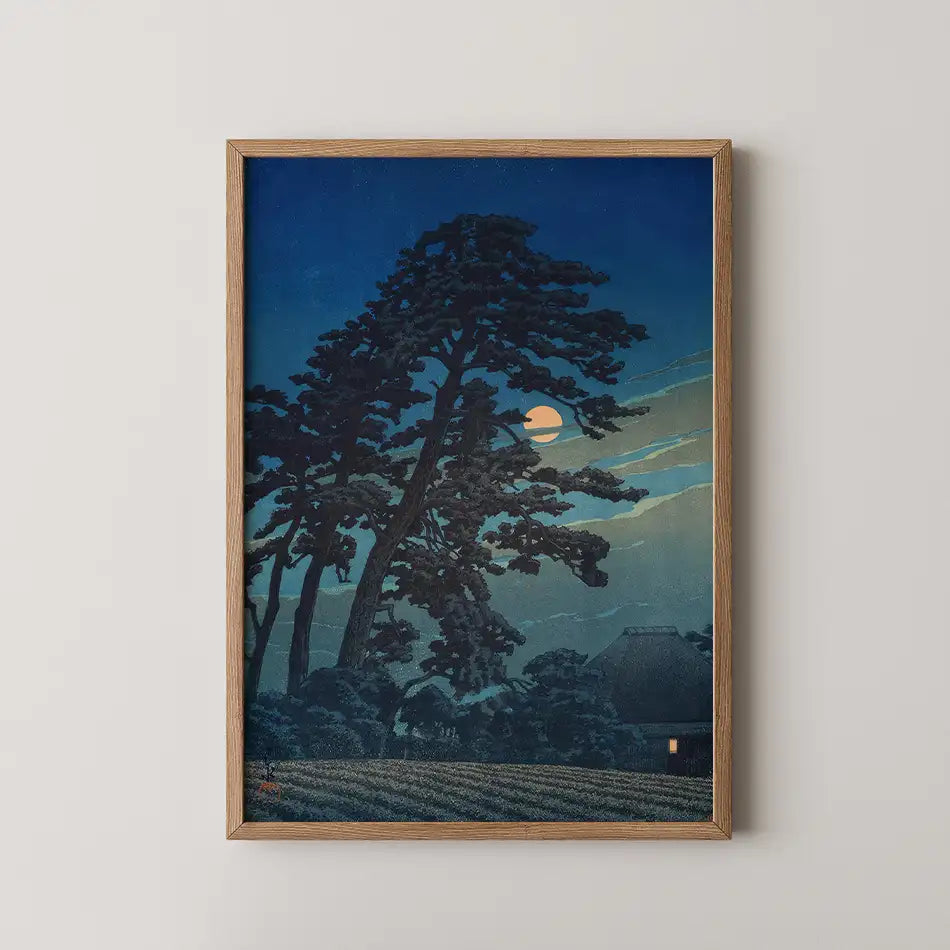 Framed painting of a moonlit landscape featuring tall trees and a small house against a deep blue night sky.