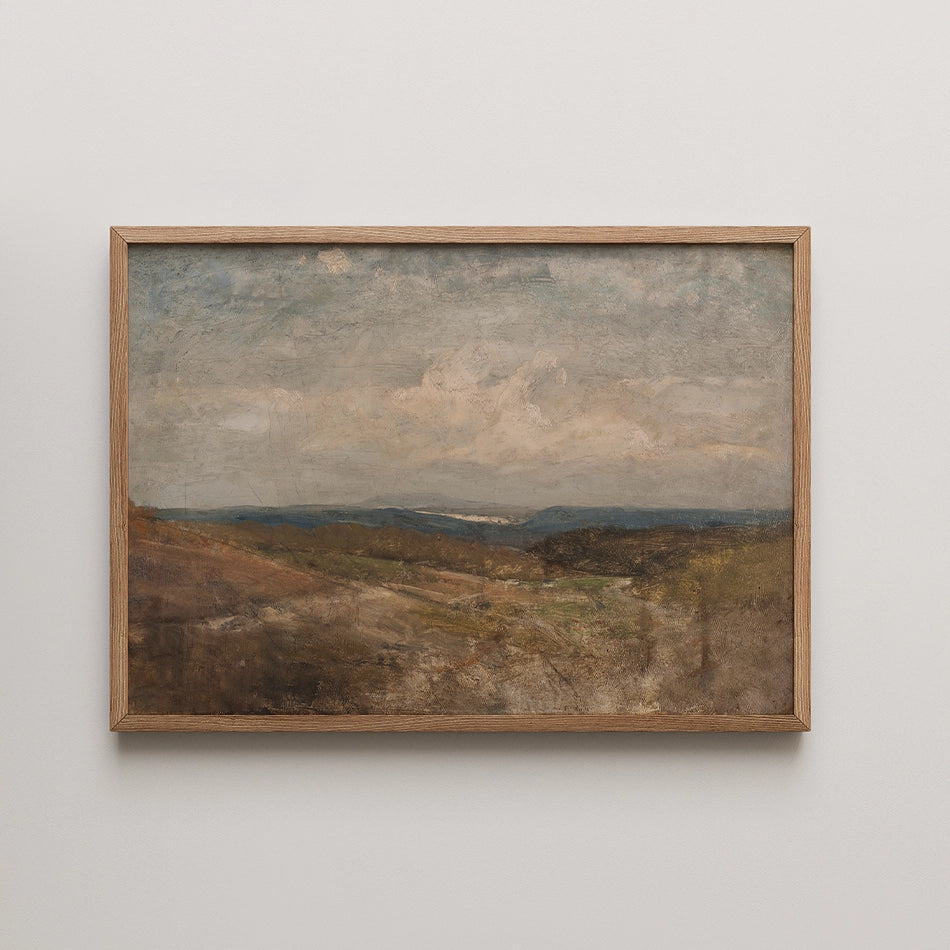 Landscape painting in a wooden frame depicting rolling hills and a cloudy sky.