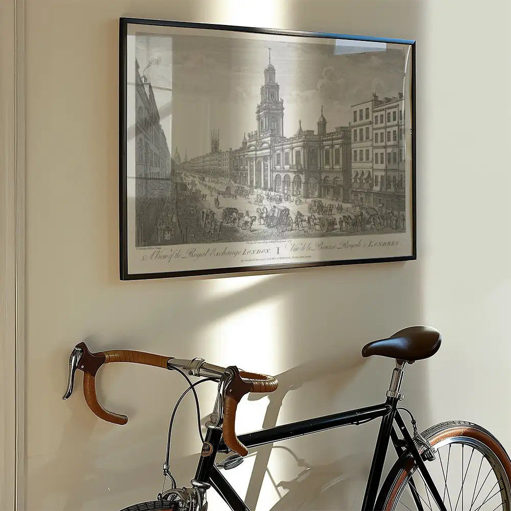 Framed black and white vintage print of a busy street scene in London hanging on a wall alongside a bicycle with leather handles.