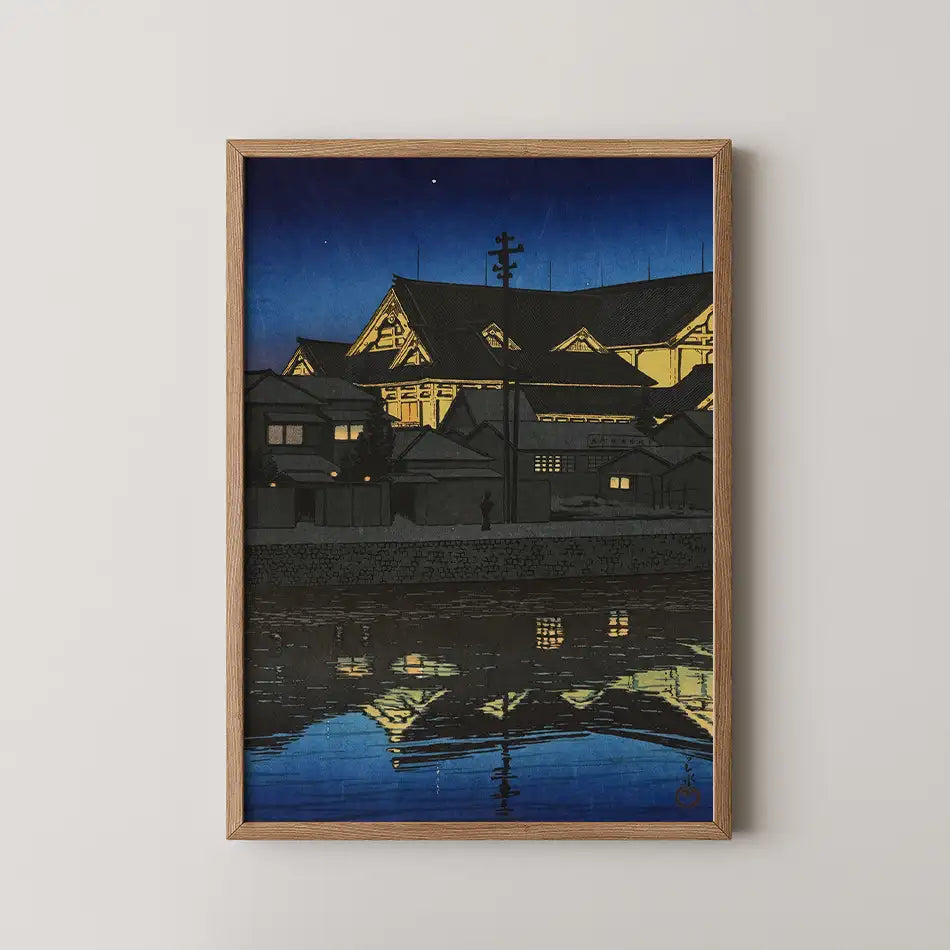 Framed painting of a serene night scene featuring traditional architectural buildings reflecting in water under a starry sky.