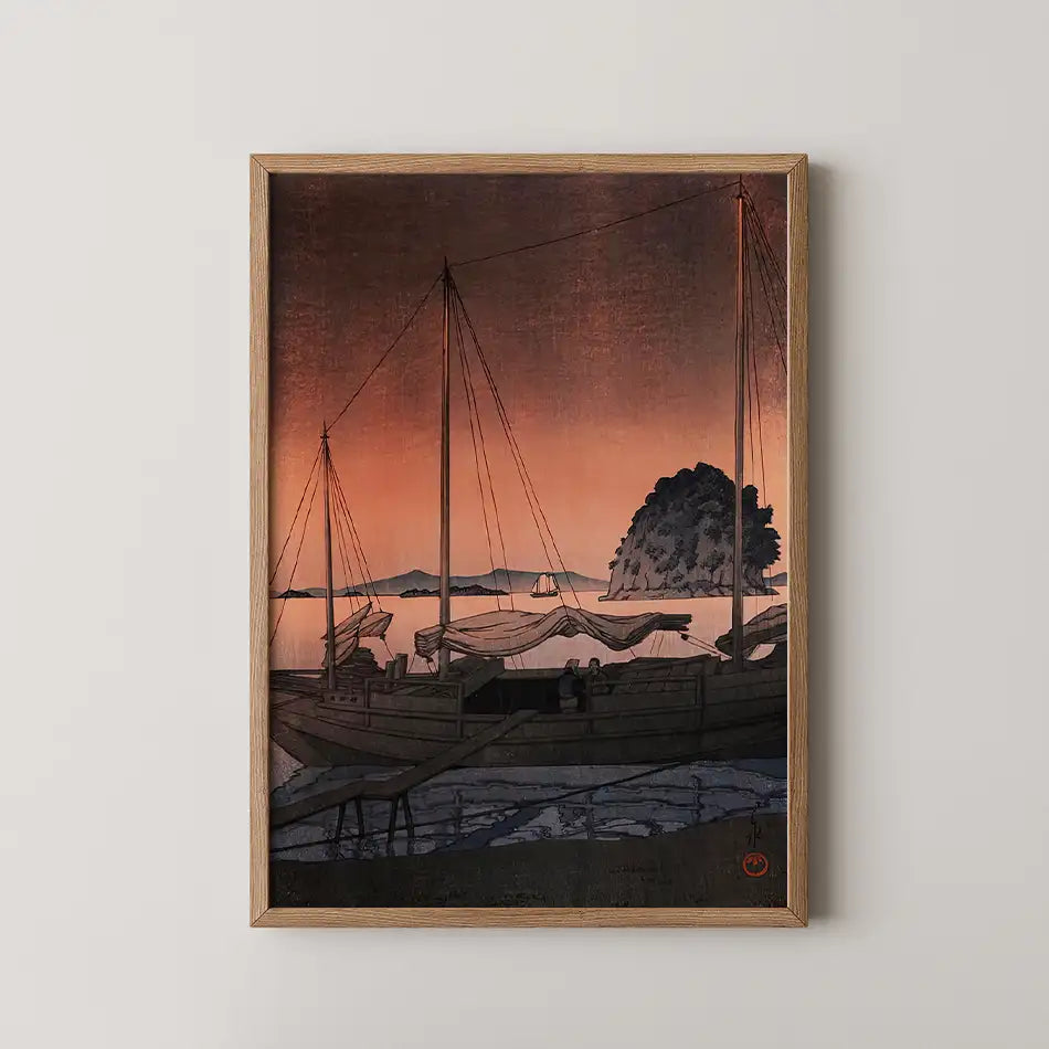 Painting of boats at sunset with a serene landscape and gentle waves, framed in wood.