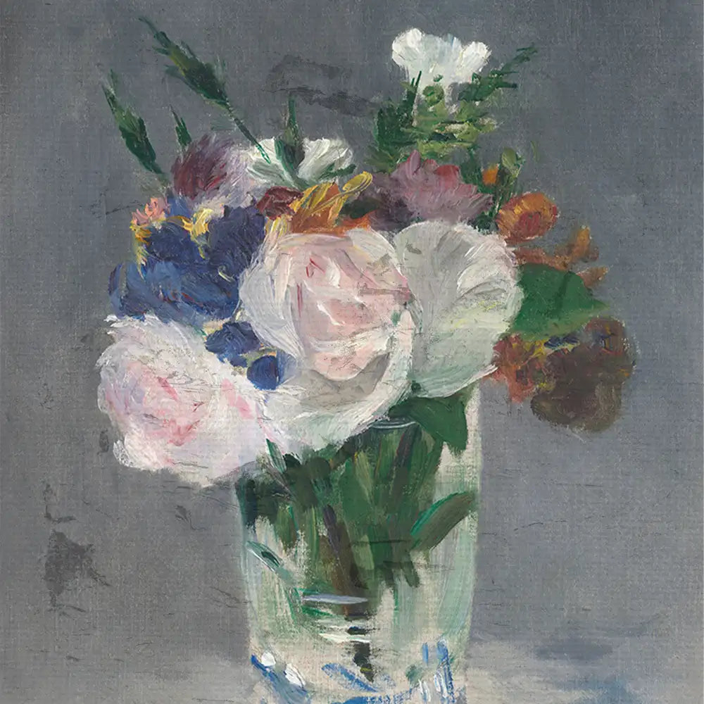 Bouquet of colorful flowers in a clear glass vase with a gray background.