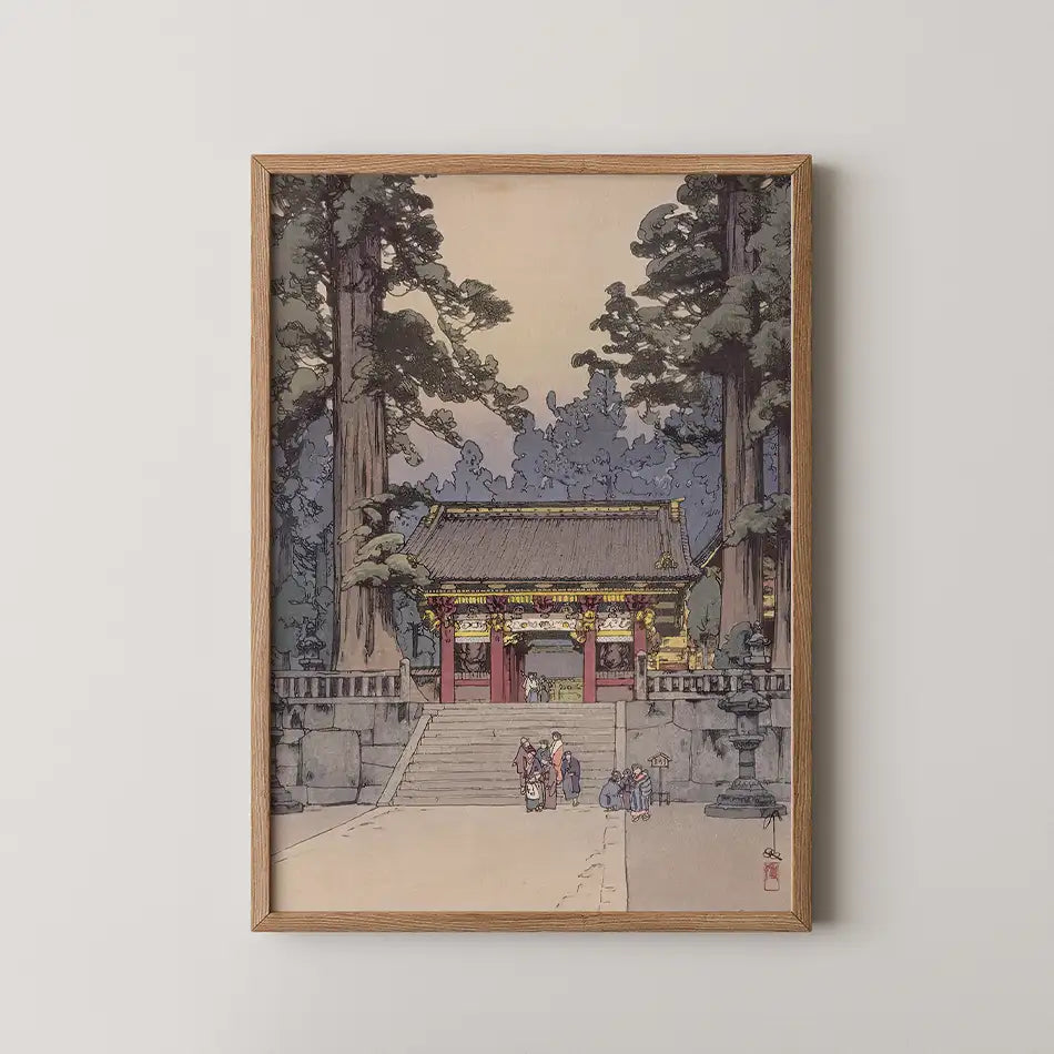 Framed painting of a traditional Japanese temple surrounded by tall trees, featuring people walking up the stone steps.