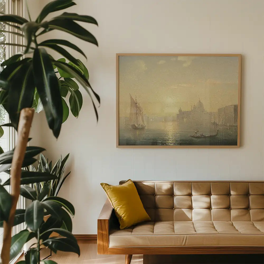 Framed painting of a serene riverside scene with sailboats, hung on a light-colored wall above a modern brown sofa with a yellow pillow, surrounded by green plants.