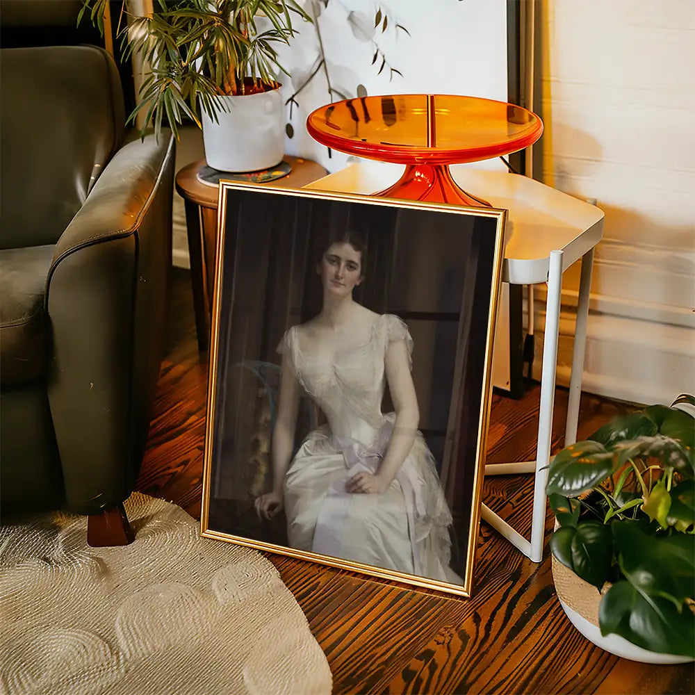 Elegant vintage portrait of a woman in a white gown displayed in a stylish living room setting, featuring a green plant and modern furniture.