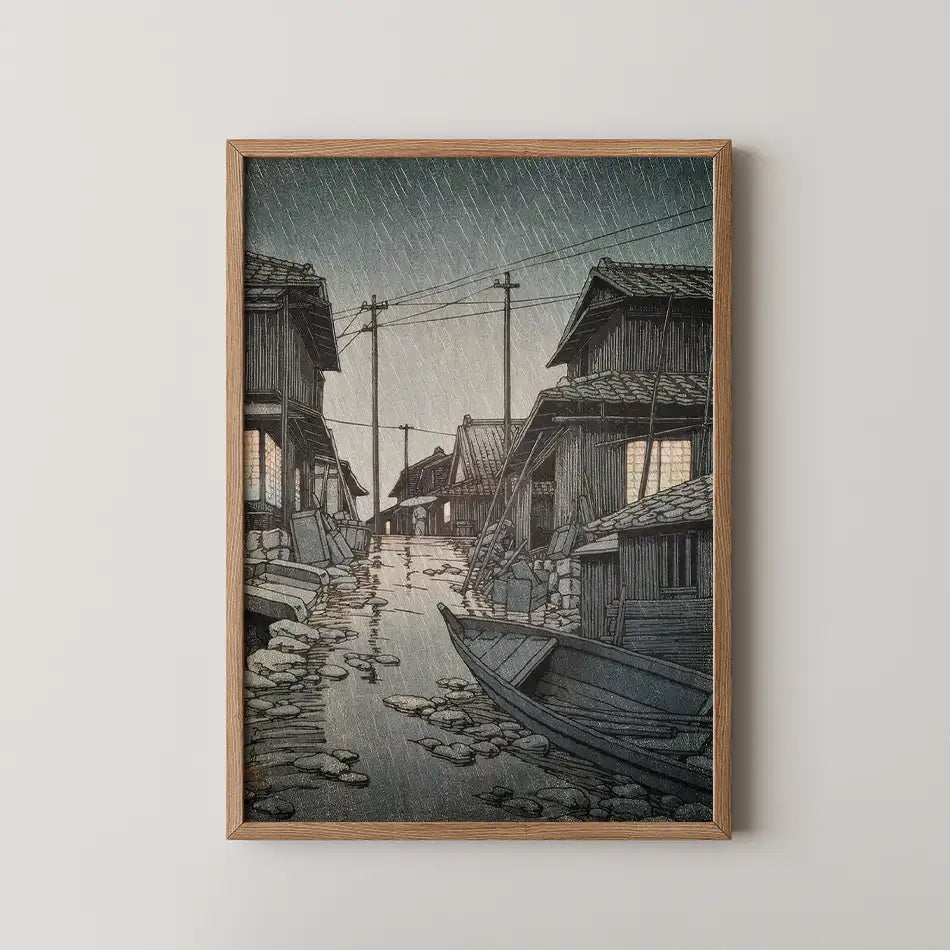 Framed painting of a rainy street scene with traditional wooden houses and a boat on the water.