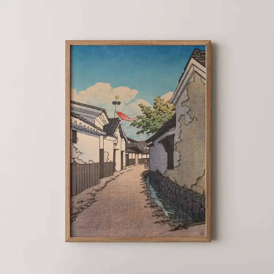 Framed painting of a serene alleyway with traditional buildings, a pathway, and a decorative fish banner against a bright blue sky.